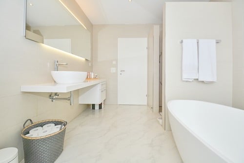 Helles, modernes Badezimmer mit freistehender Wanne und Waschtisch