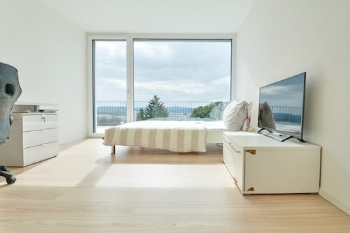 Helles minimalistisches Schlafzimmer mit großem Fenster