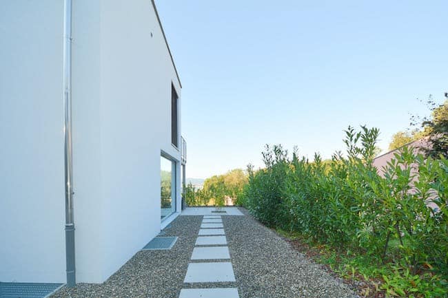 Seitlicher Außenbereich mit Gartenweg entlang des Hauses