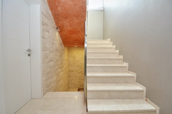 Treppenhaus mit Naturstein und weißer Treppe