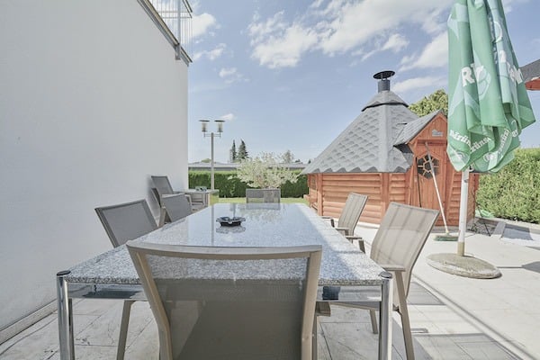 Terrasse mit Esstisch und Grillhütte
