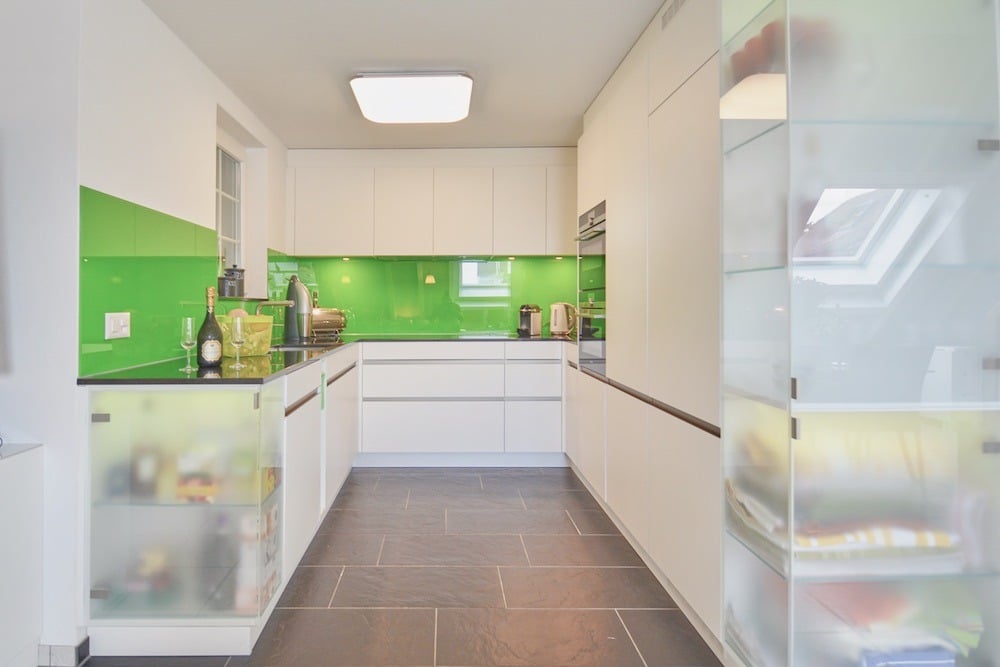 Moderne Einbauküche mit farbigem Spritzschutz