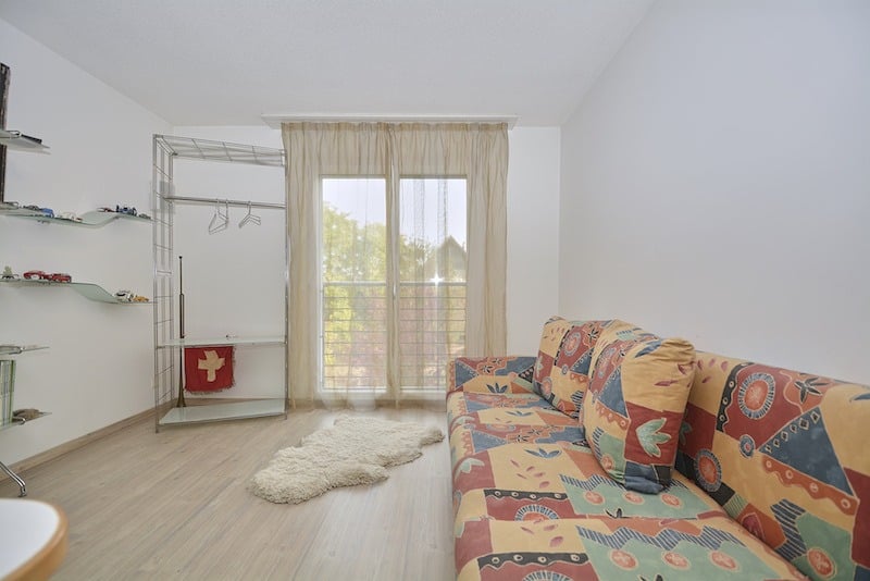 Helles Zimmer mit Sofa und Garderobenbereich