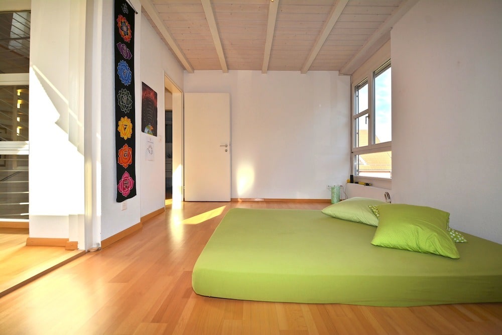 Helles Schlafzimmer mit grünem Futon