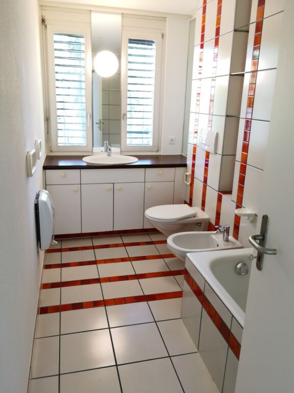 Modernes Badezimmer mit roten Akzenten
