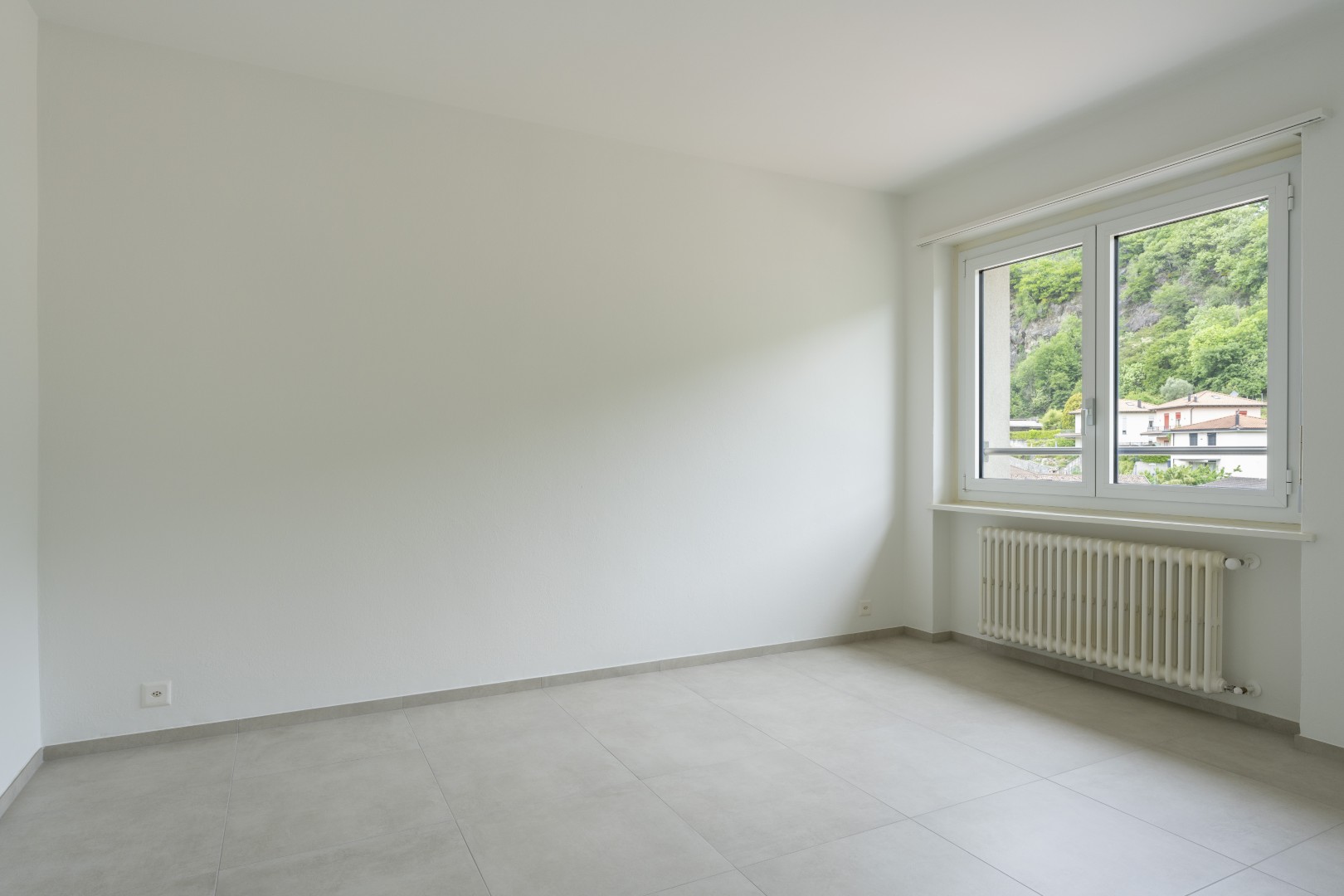 Heller leerer Raum mit Fenster und Heizkörper