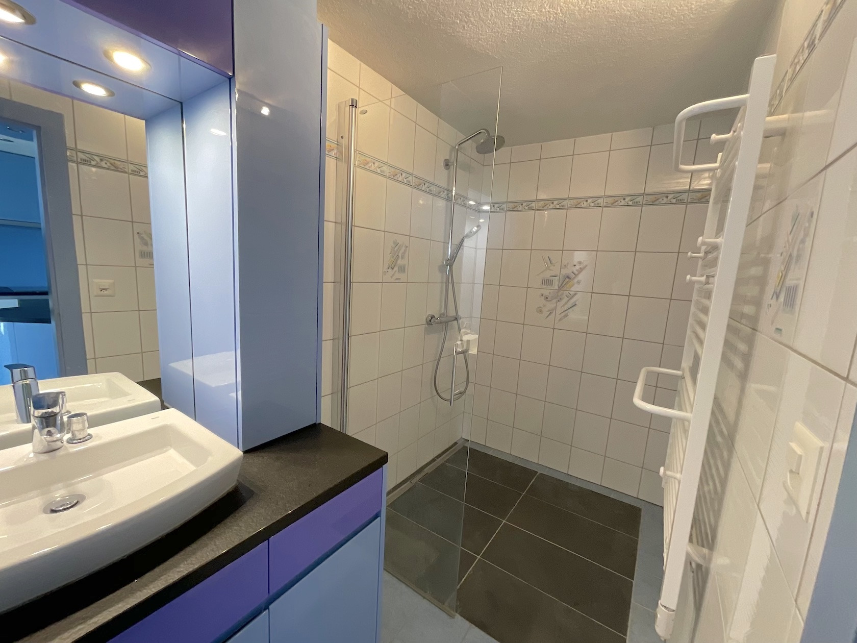 Badezimmer mit Dusche und Doppelwaschbecken