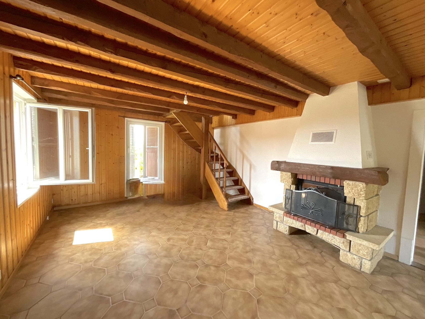 Rustikaler Wohnraum mit Kamin und Holzdecke