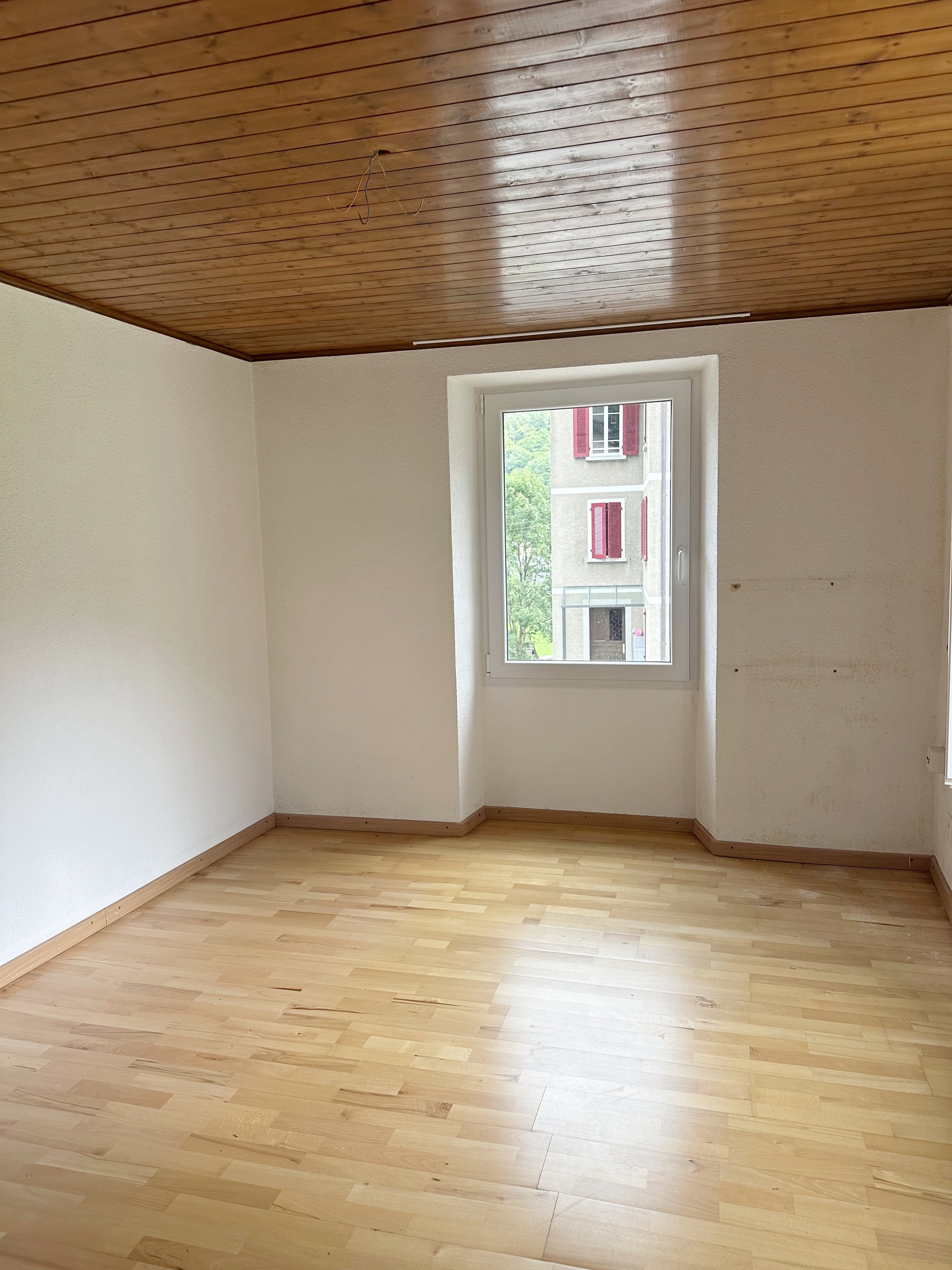 Leerer Wohnraum mit Holzdecke und Fenster