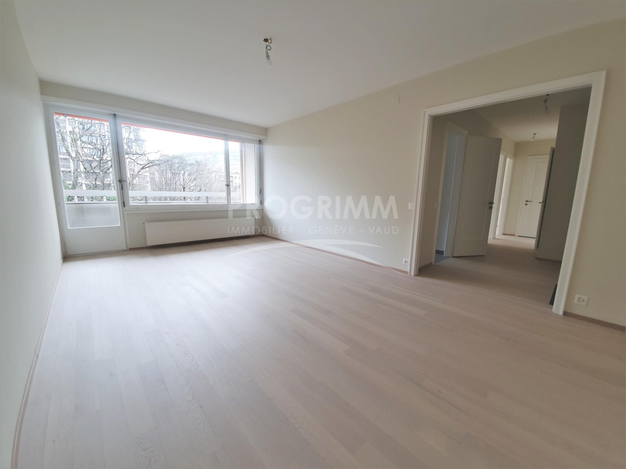 Helles, leeres Wohn-/Schlafzimmer mit großen Fenstern