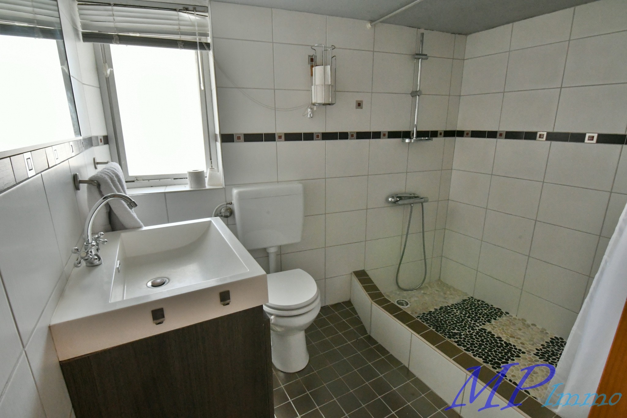 Modernes Badezimmer mit Dusche und Waschplatz