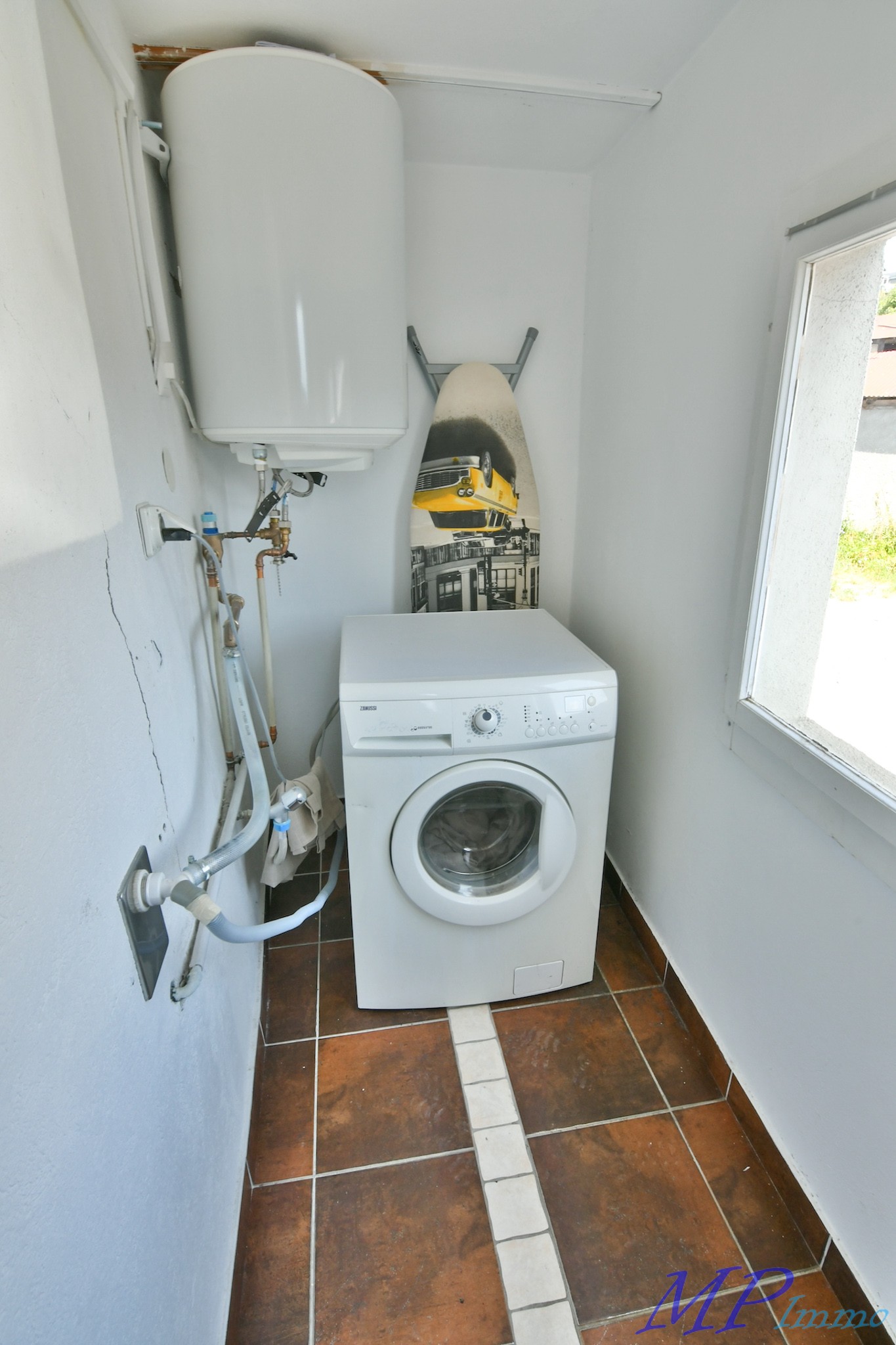 Hauswirtschaftsraum mit Waschmaschine und Warmwasserspeicher