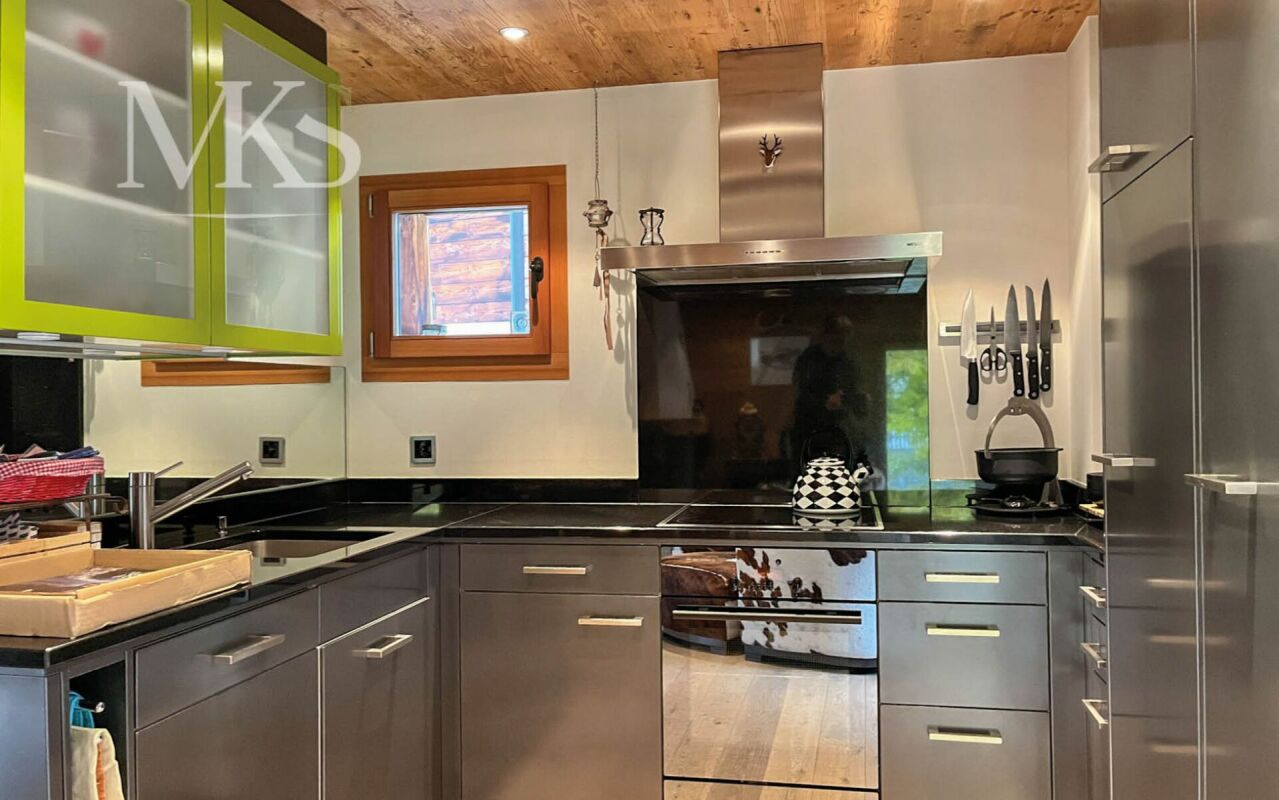 Moderne Küche mit Edelstahlgeräten und Holzdecke