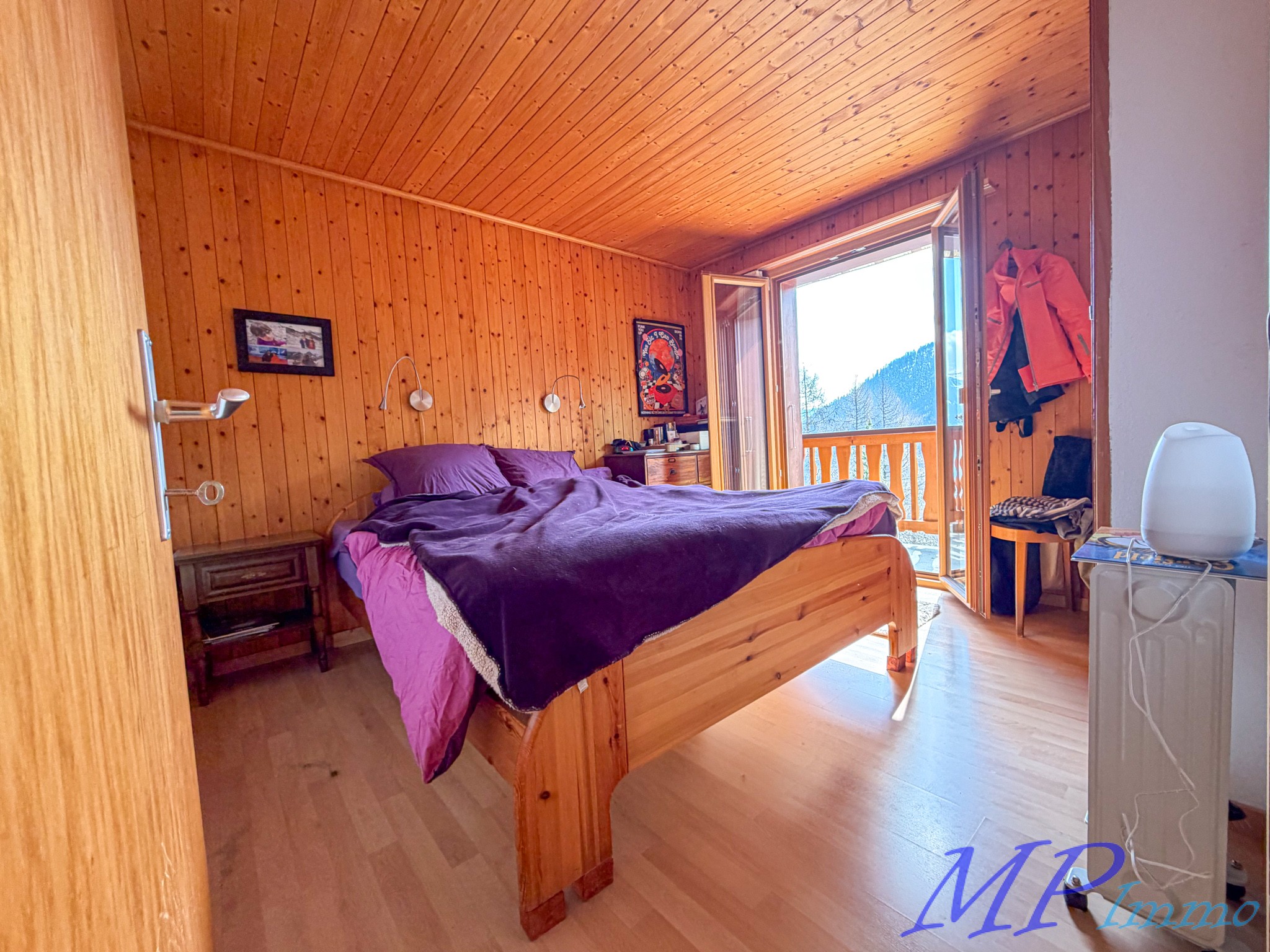 Gemütliches Holz-Schlafzimmer mit Balkonblick