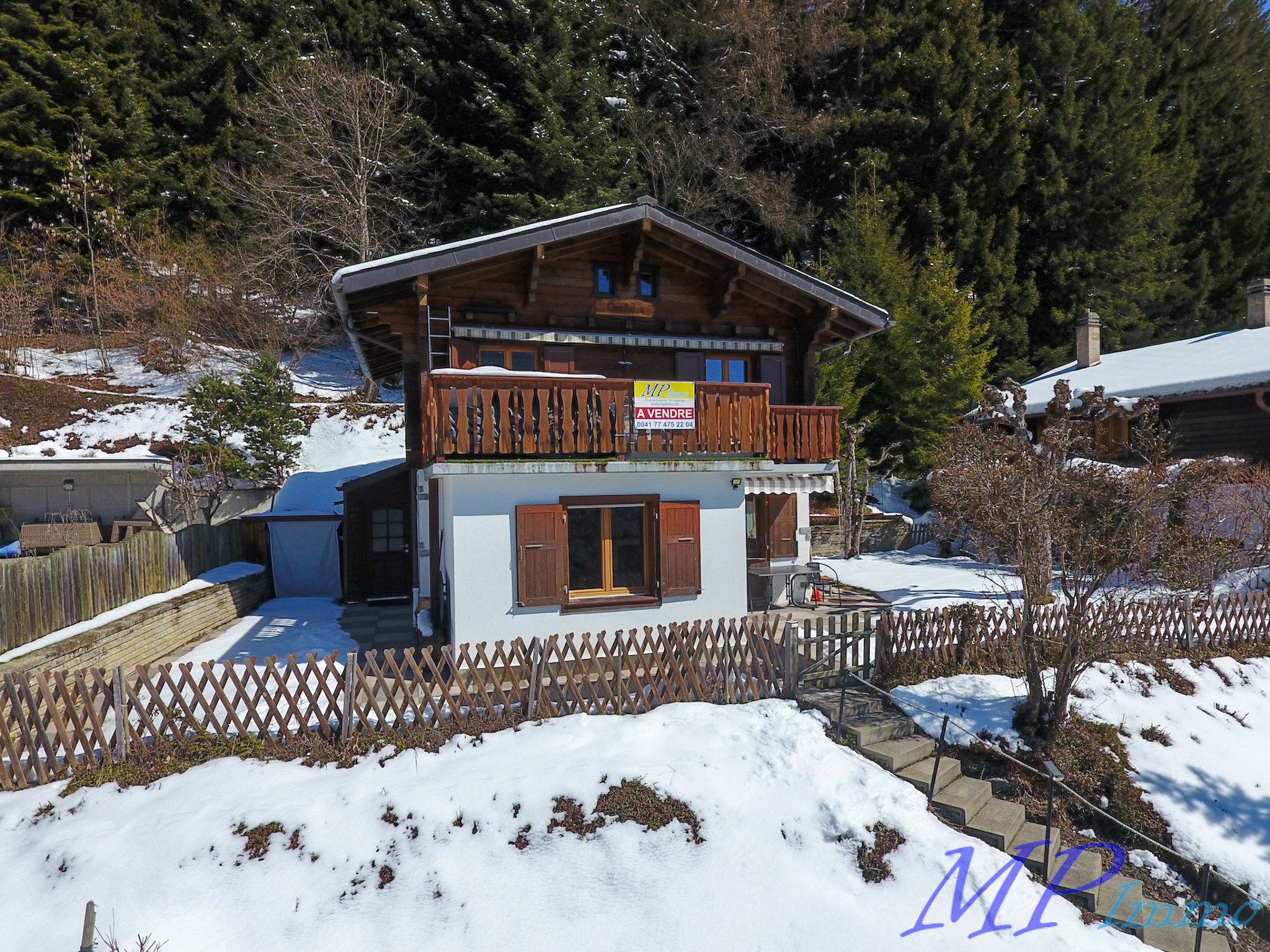 Schneebedecktes Holzchalet mit Balkon