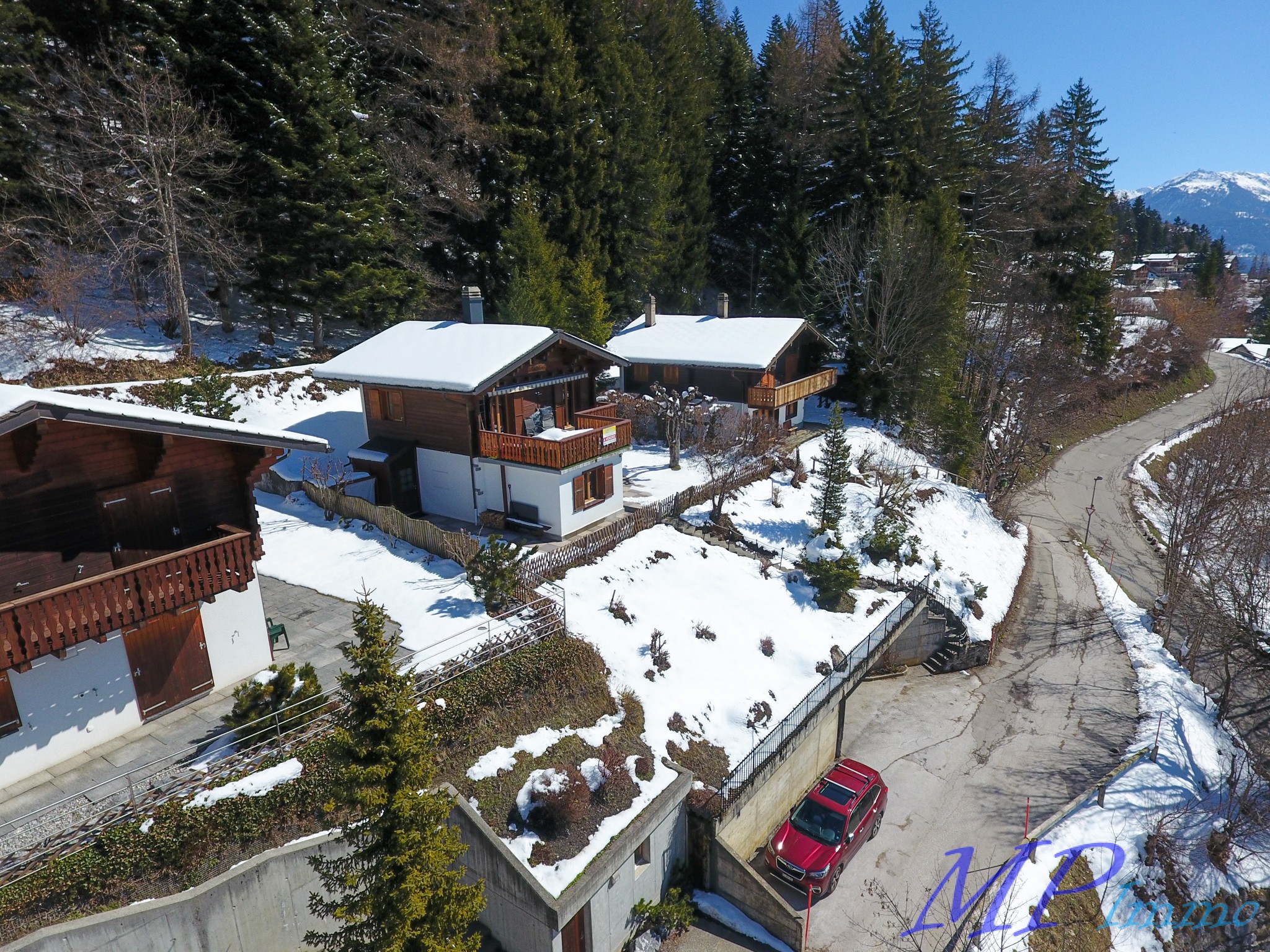 Alpine Ferienhäuser in verschneiter Hanglage