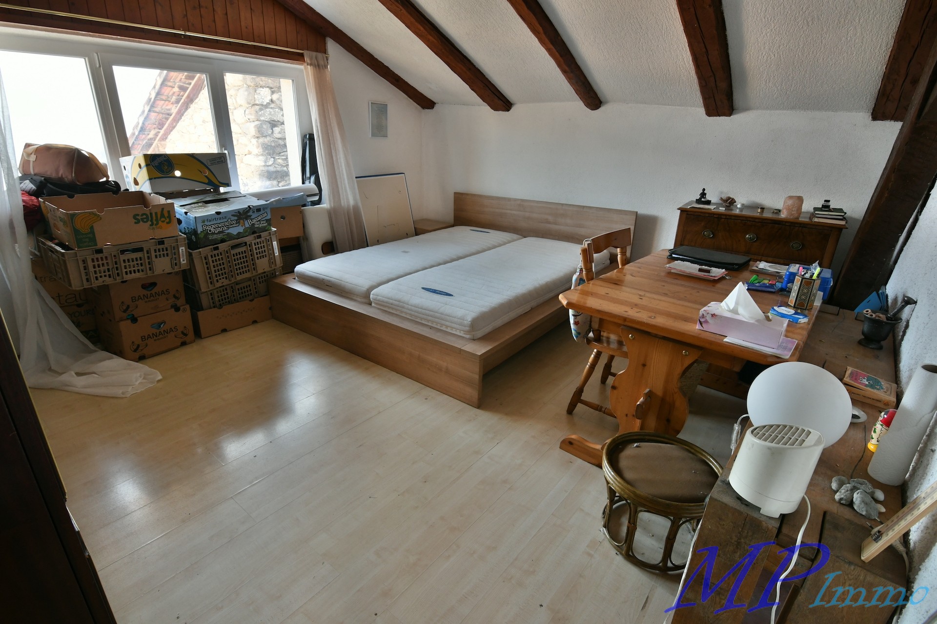Dachzimmer mit Bett und Arbeitstisch