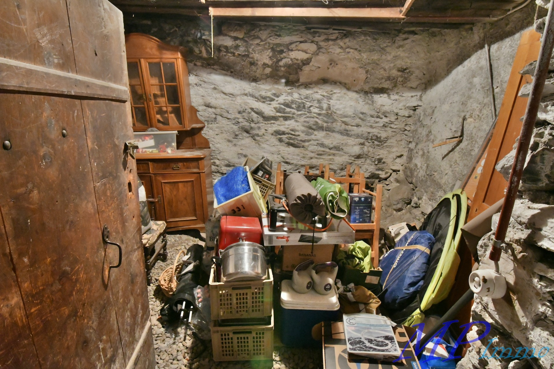 Unordentlicher Kellerraum mit Natursteinwänden