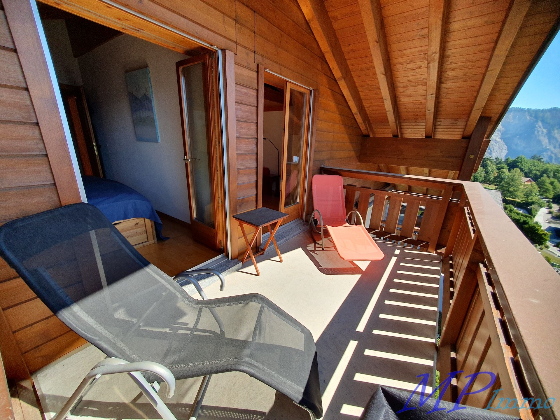 Holzbalkon mit Liegestühlen