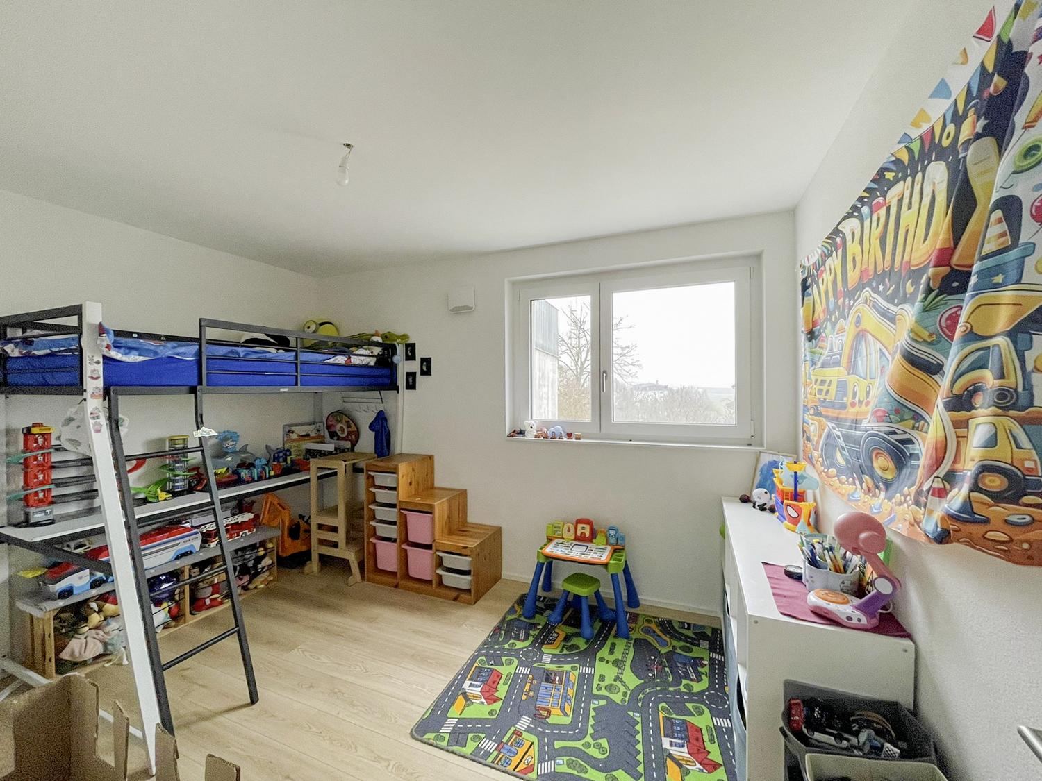 Kinderzimmer mit Hochbett und Spielbereich
