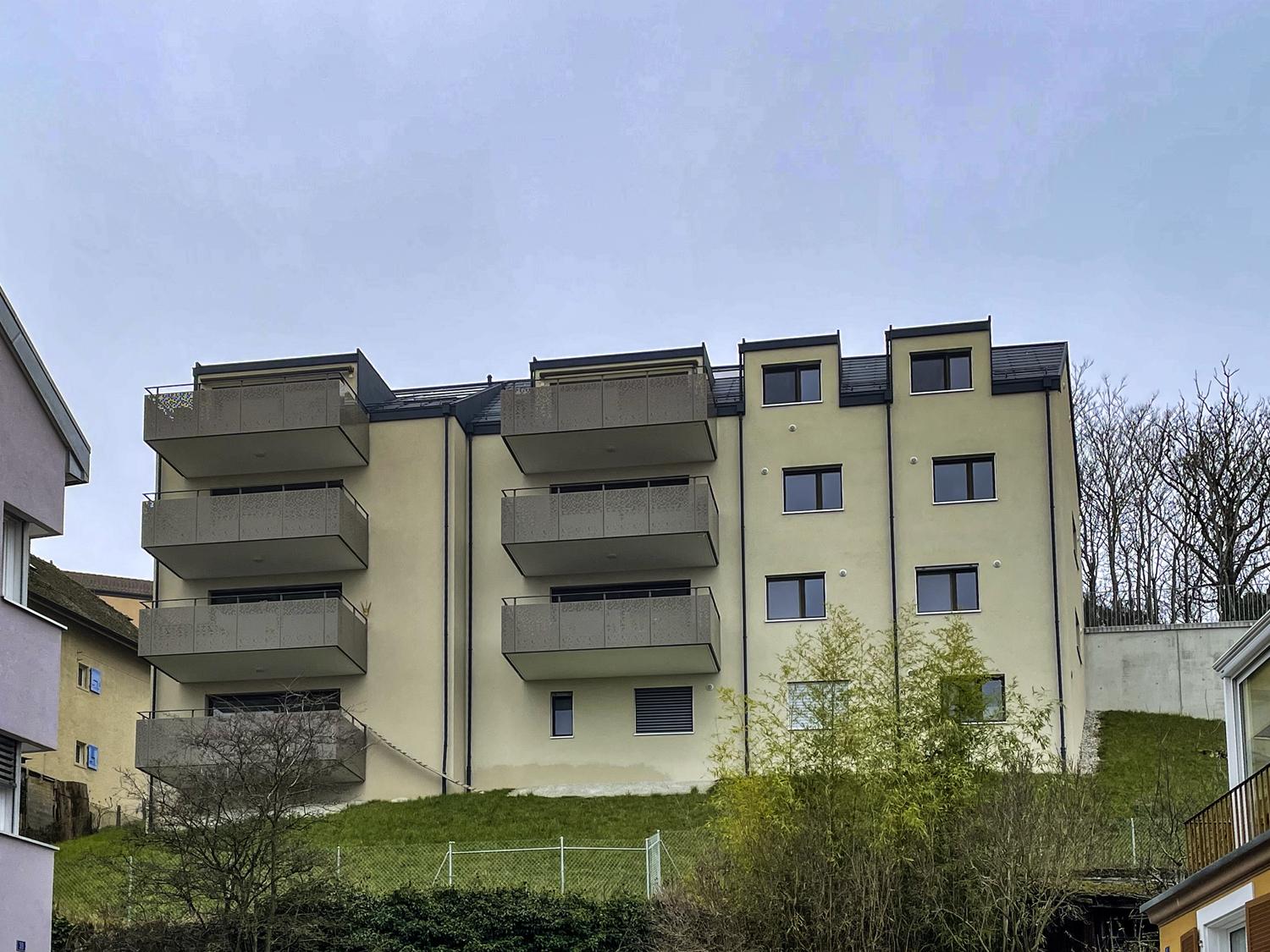 Mehrfamilienhaus mit Balkonen am Hang