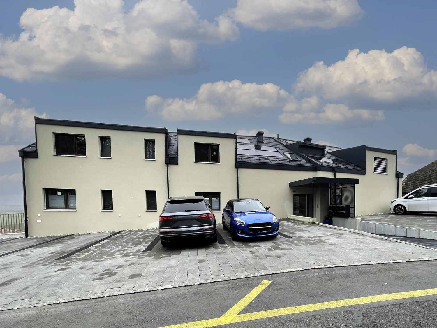 Moderne Außenansicht eines Wohngebäudes mit Stellplätzen