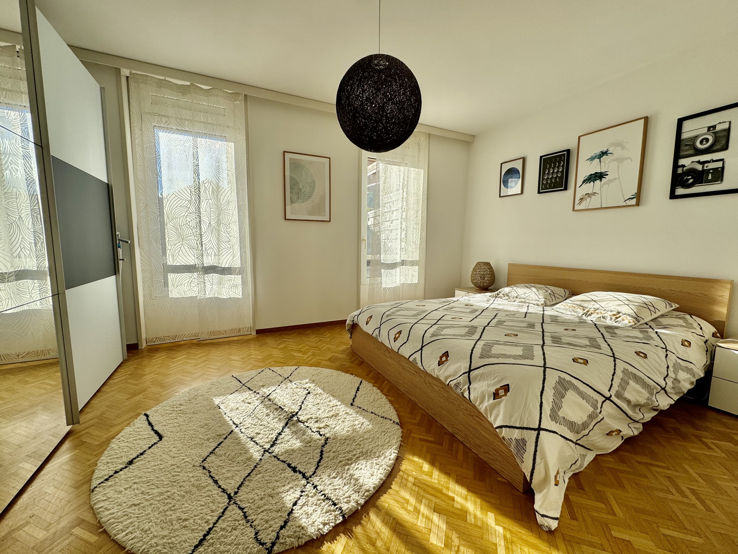 Helles Schlafzimmer mit Parkettboden und dekorativem Tageslicht