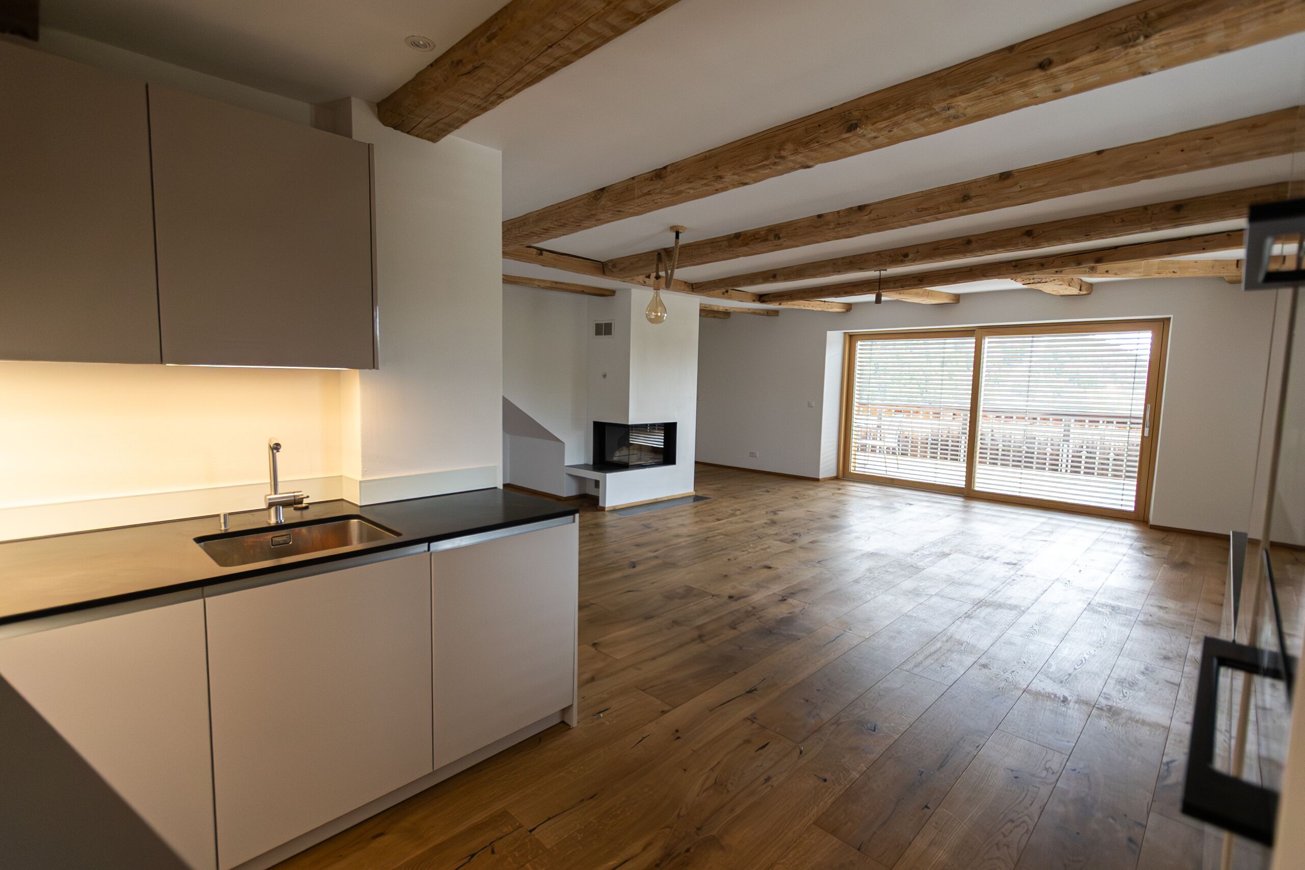 Offener Wohnbereich mit Küche und Kamin