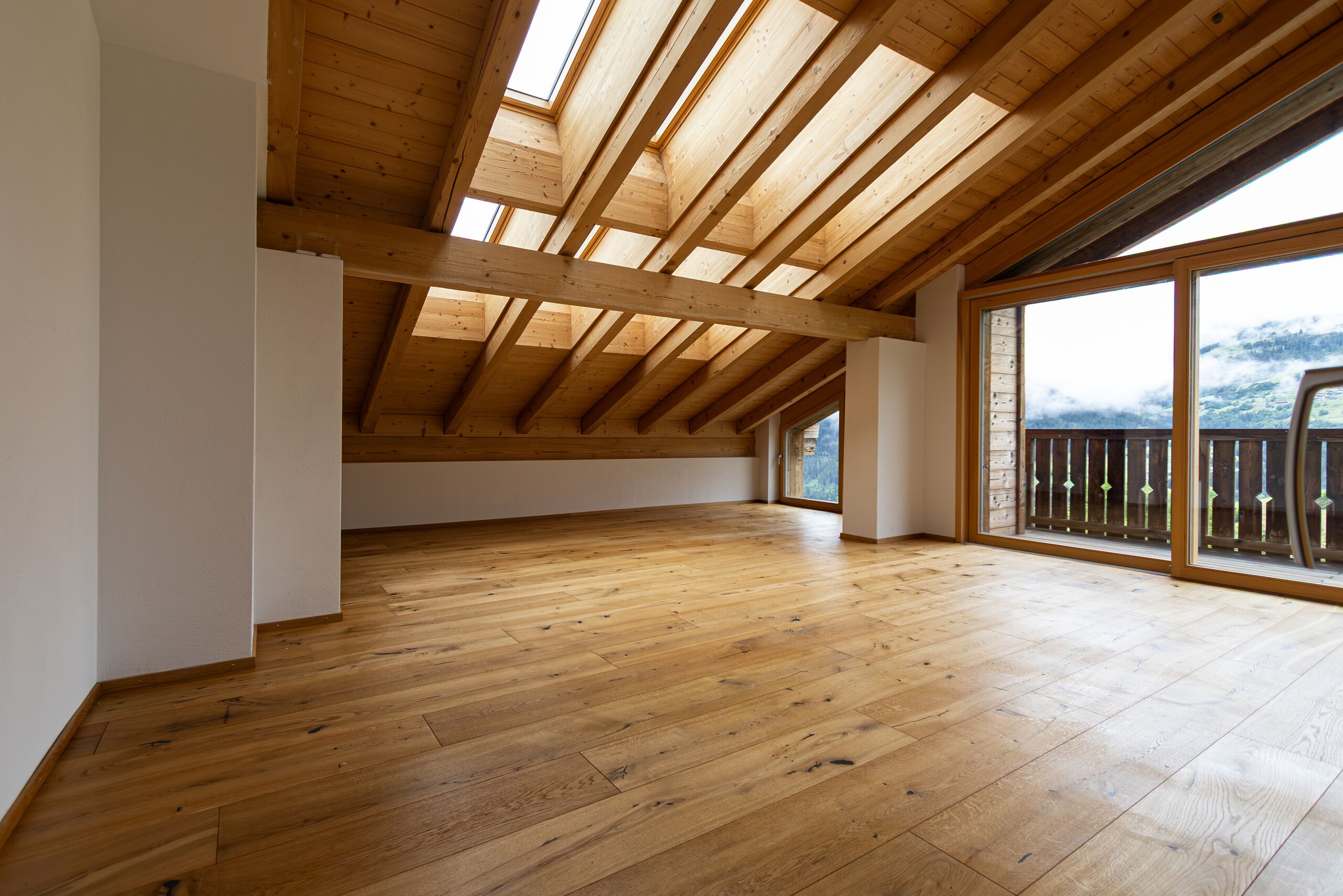 Ausgebauter Dachraum mit Holzdecke und Balkonblick