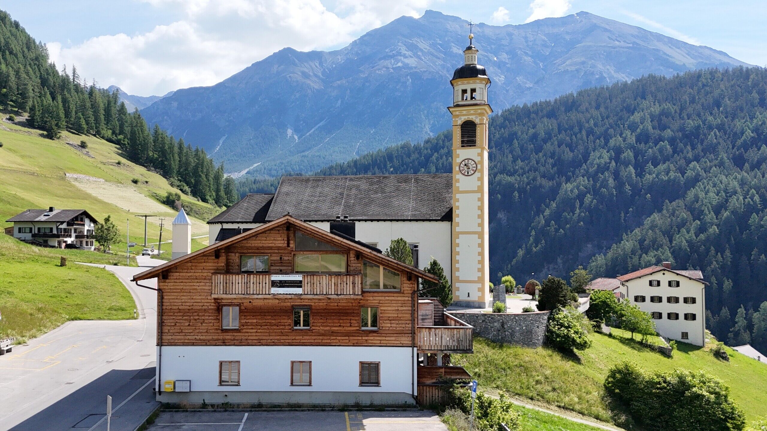 Alpenlandschaft mit Kirche und Holzhaus