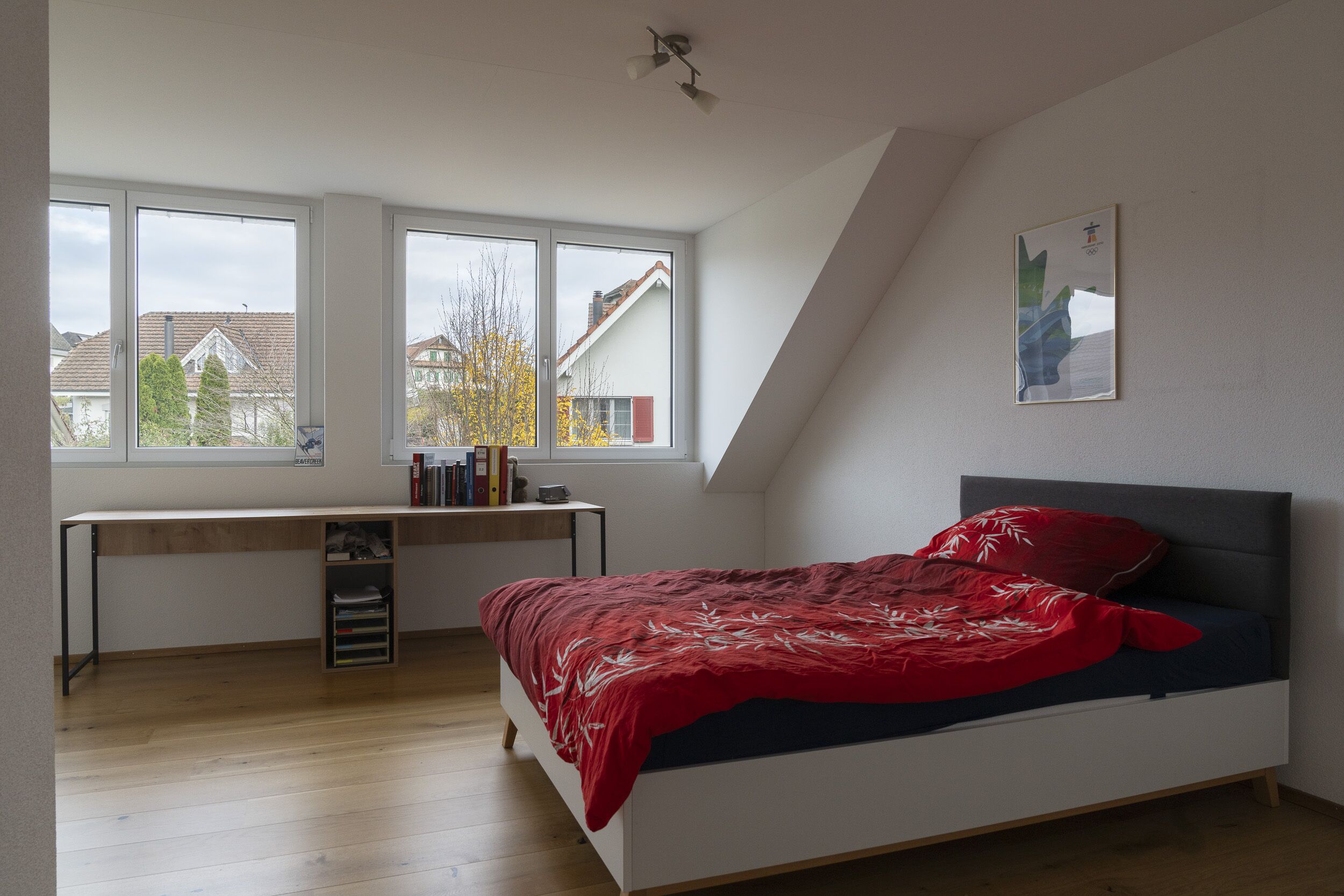Schlafzimmer mit Dachschräge und großen Fenstern