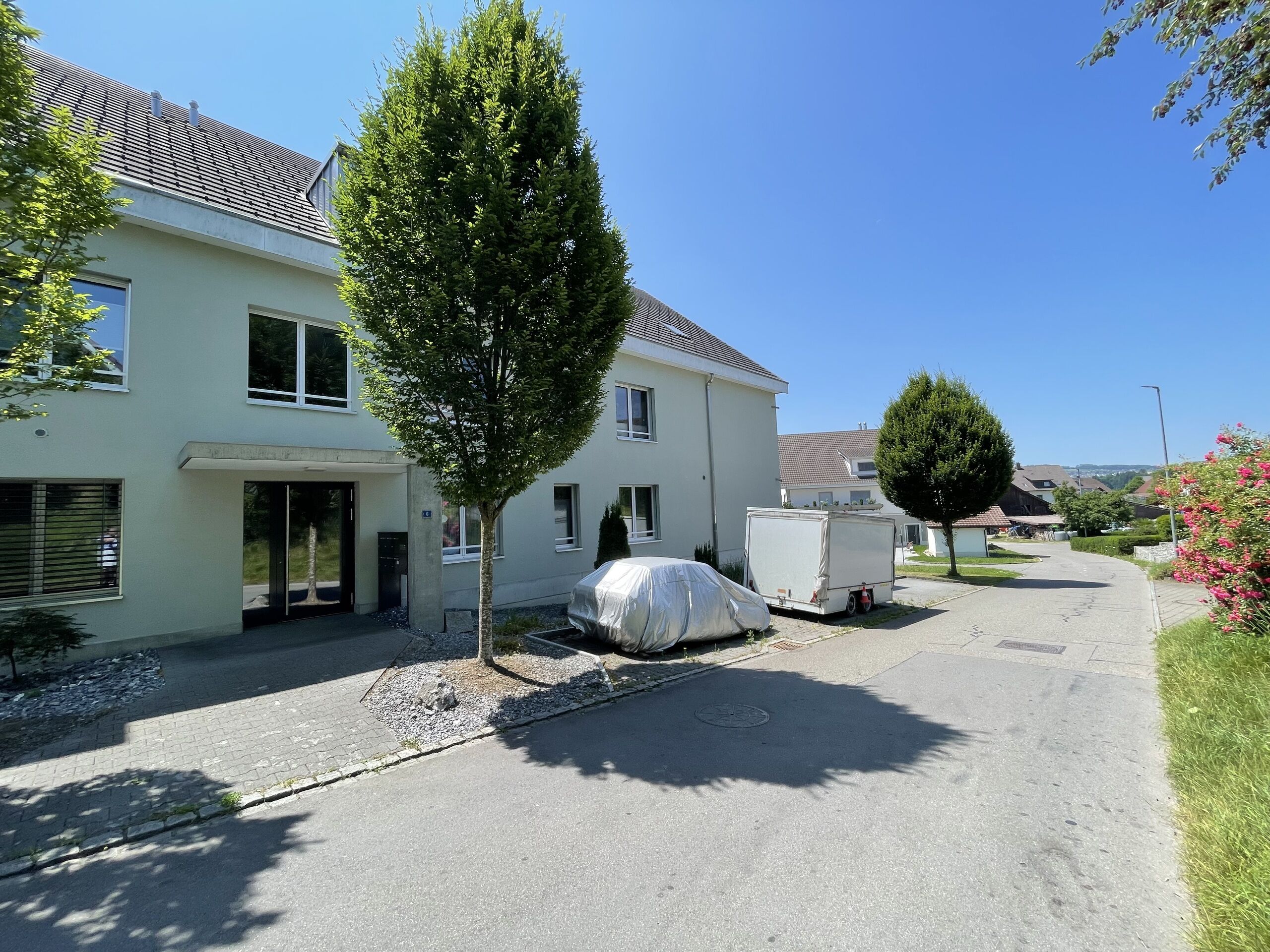 Außenansicht eines Wohnhauses in sonniger Wohnstraße