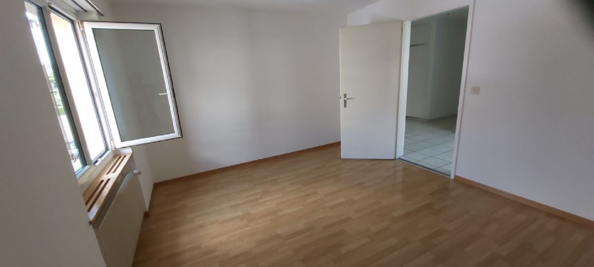 Leerer Wohnraum mit Fenster und offener Tür
