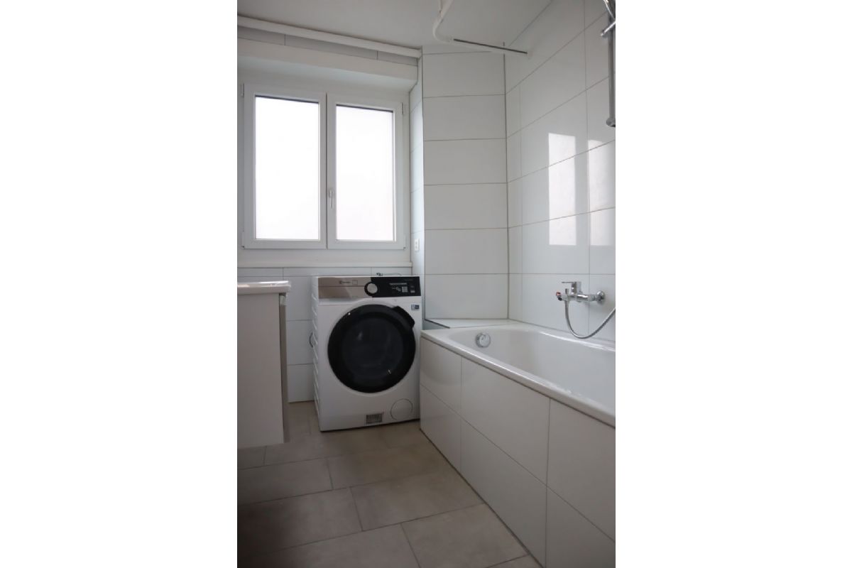 Badezimmer mit Badewanne und Waschmaschine