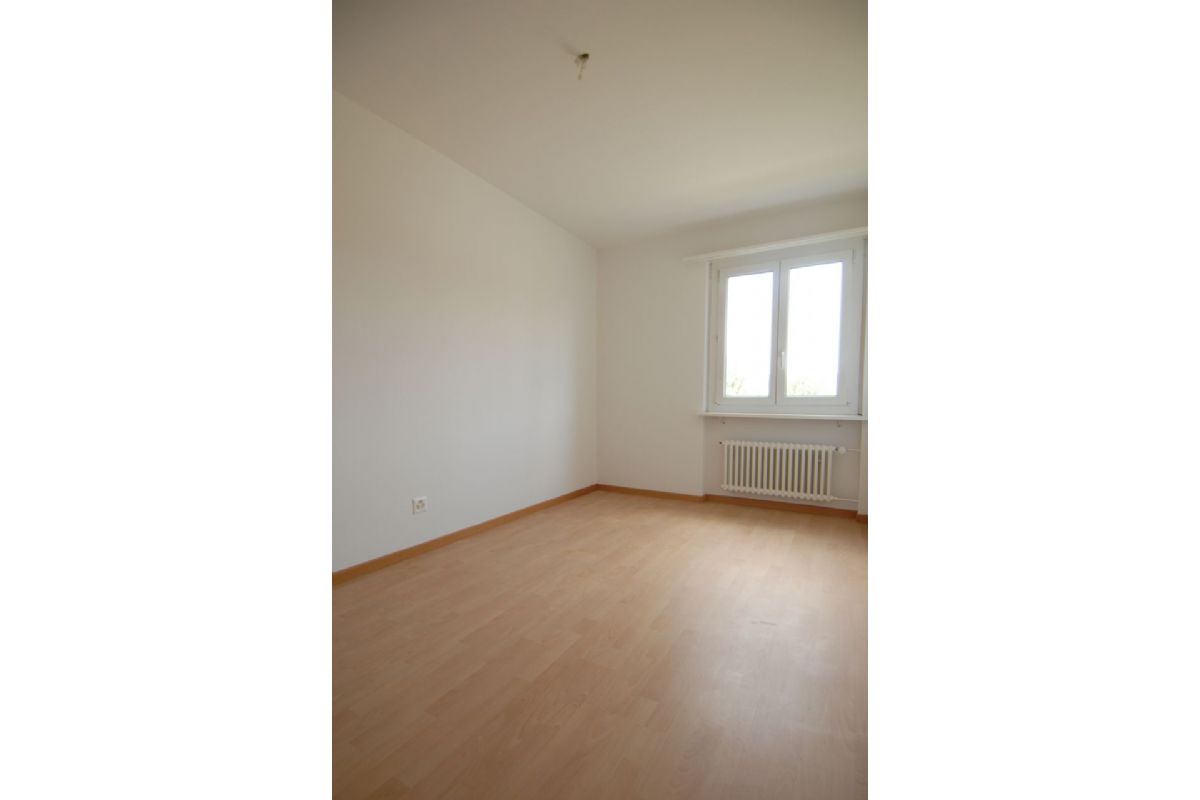 Leerer heller Raum mit Fenster und Heizkörper