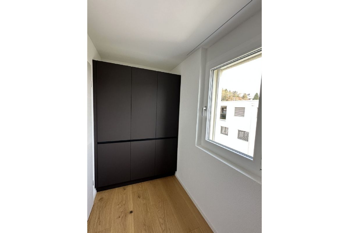 Kleiner heller Raum mit Einbauschrank und Fenster