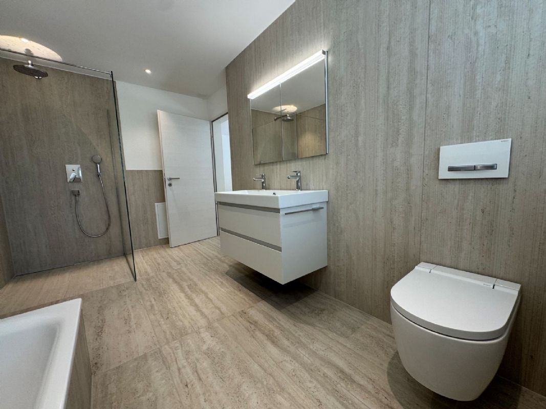 Modernes Badezimmer mit Dusche, Waschtisch und wandhängendem WC