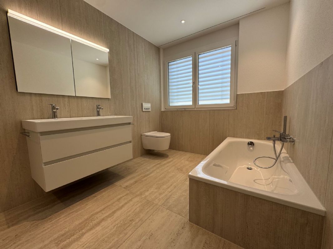 Modernes Badezimmer mit Doppelwaschtisch, Wanne und WC