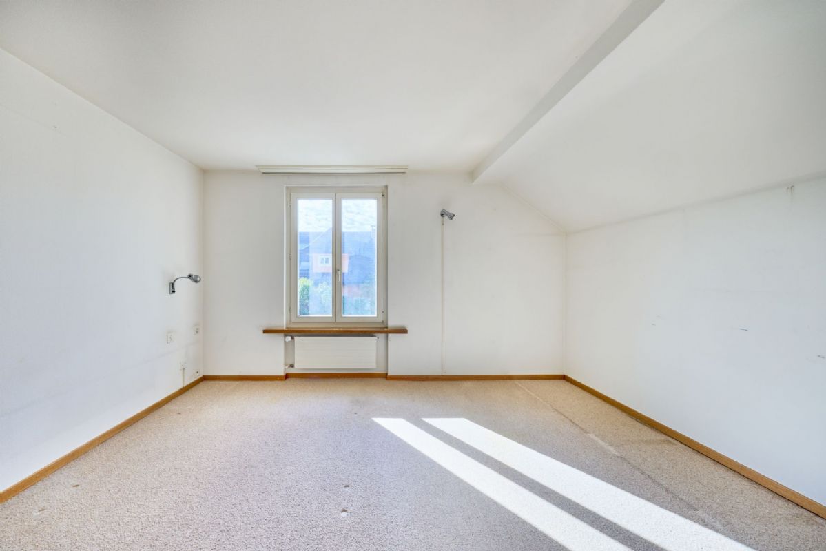 Heller leerer Raum mit Dachschräge und Fenster