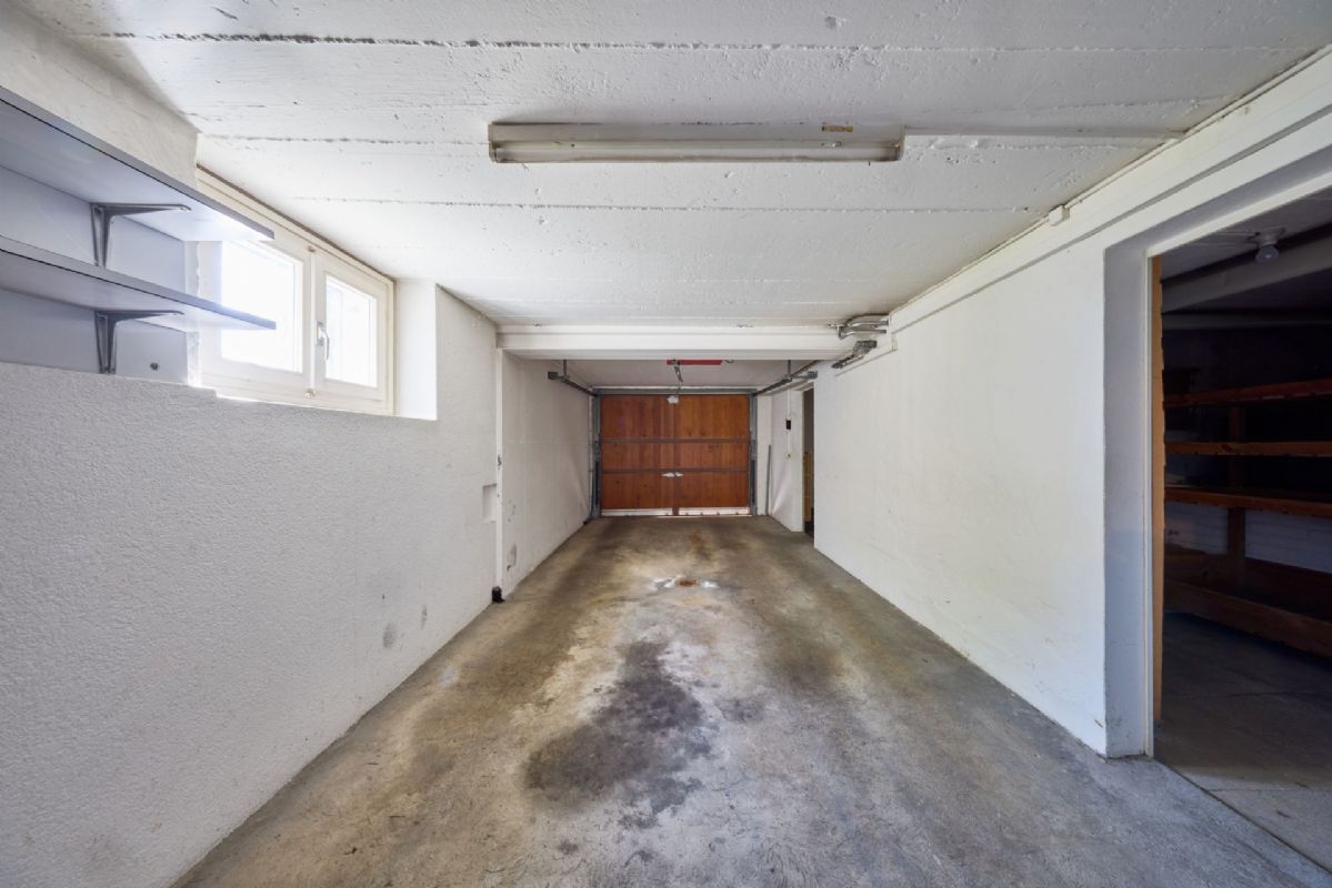 Garage mit Zugangstür und Sichtbetonboden