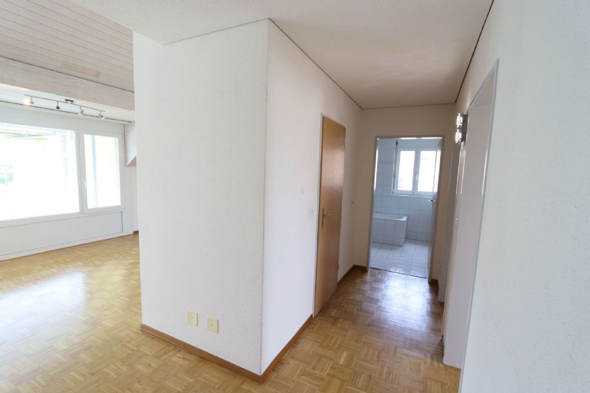 Flur mit angrenzendem Wohnbereich und Blick ins Bad