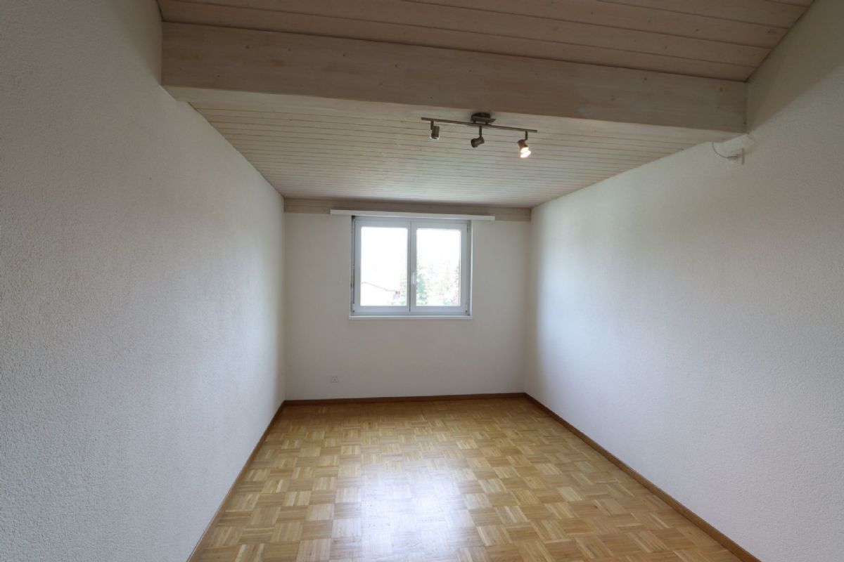 Leerer Raum mit Holzdecke und Parkettboden