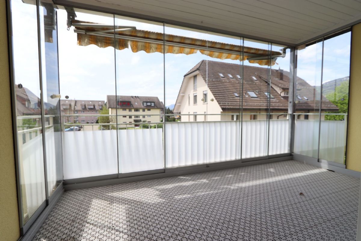 Verglaster Balkon mit Blick auf Wohnhäuser