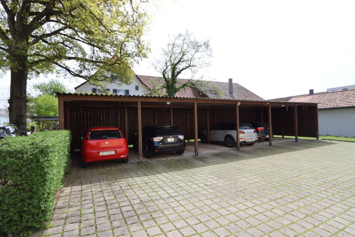 Überdachter Stellplatz vor einem Wohnhaus
