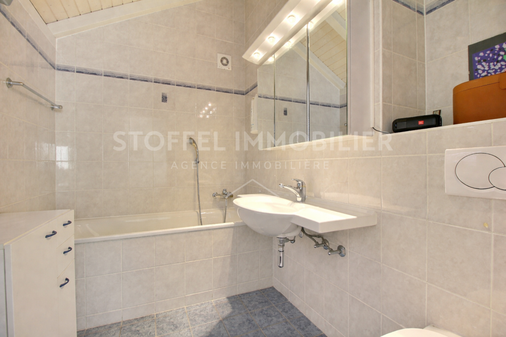 Badezimmer mit Badewanne und Waschtisch unter Dachschräge