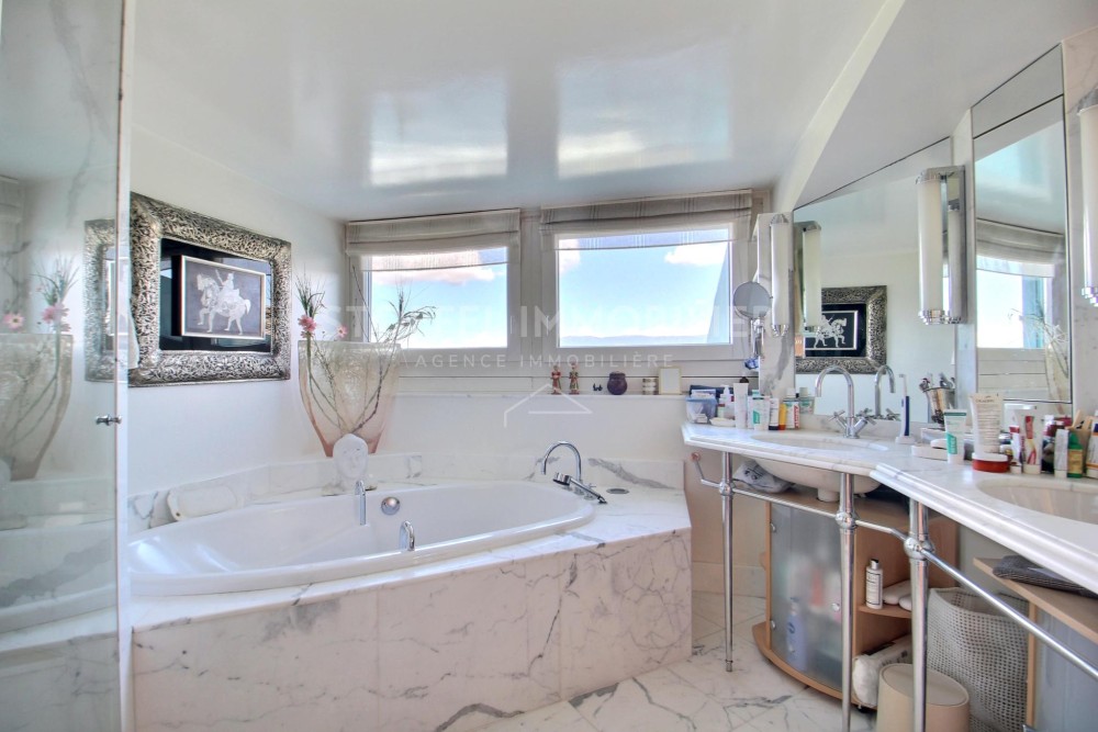 Helles Badezimmer mit Eckbadewanne und Doppelwaschtisch