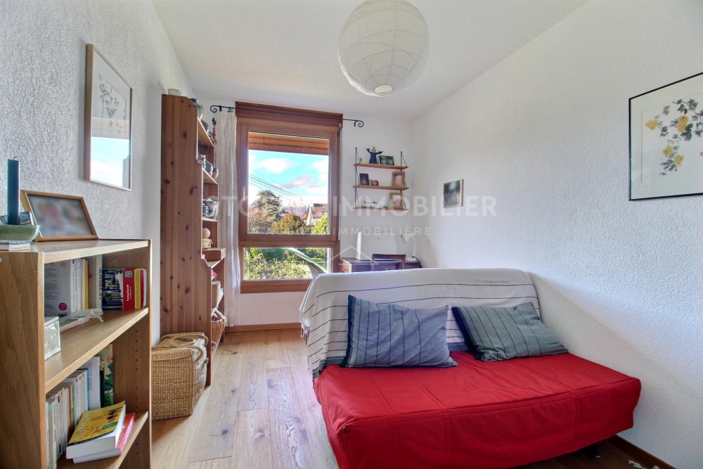 Helles Schlafzimmer mit Sitzmöglichkeit und Holzfenster
