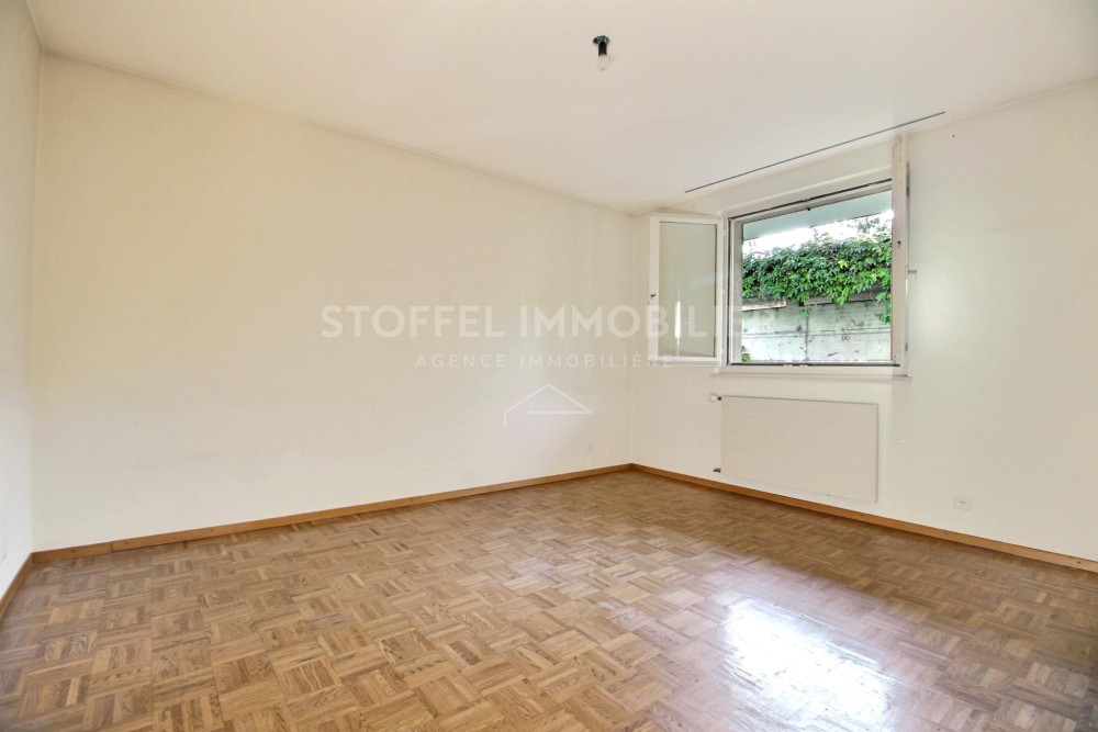 Leerer heller Raum mit Parkettboden und Fenster