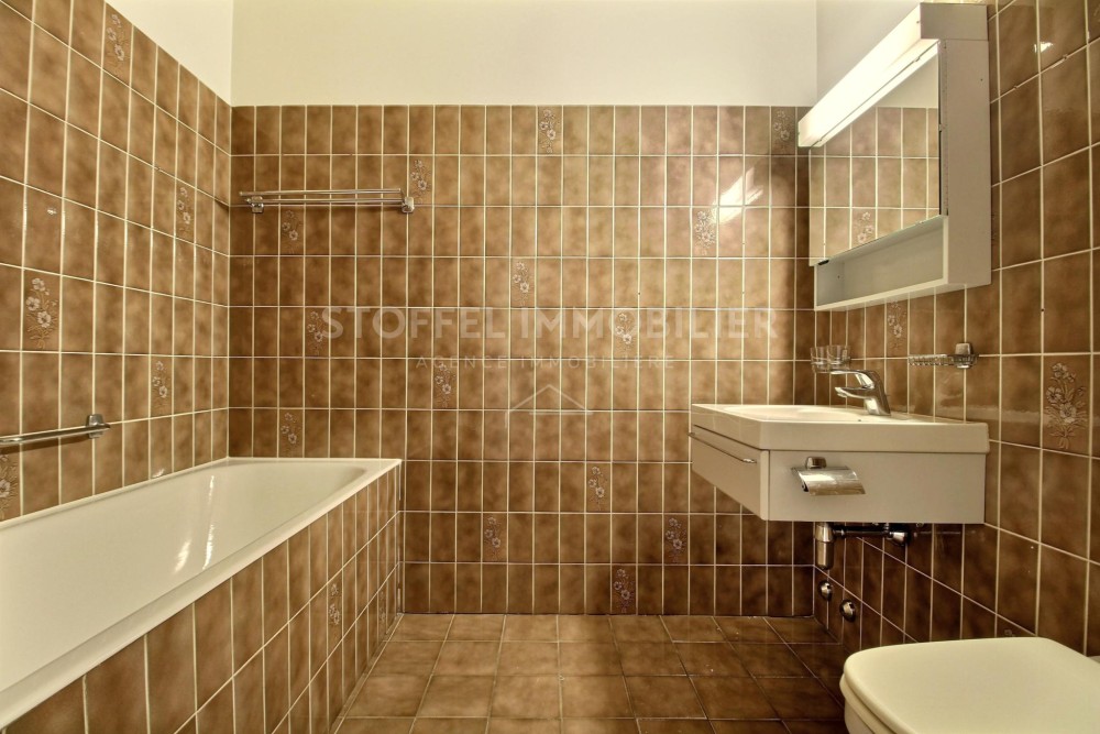 Braunes Badezimmer mit Badewanne und Waschbecken