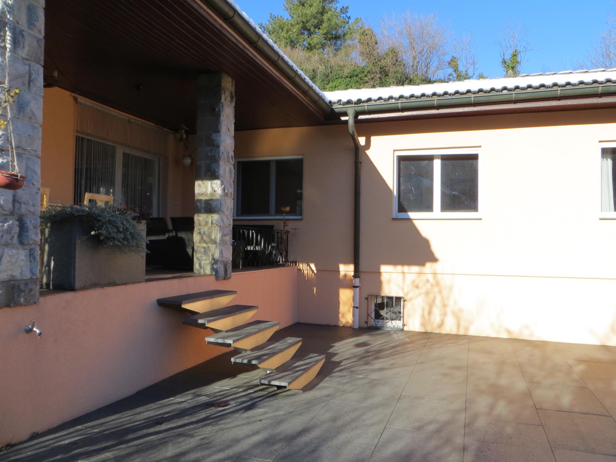 Überdachte Terrasse mit Steinfassade
